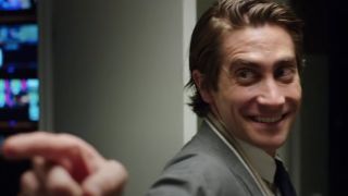 Jake Gyllenhaal smiling and pointing in the office in Nightcrawler.