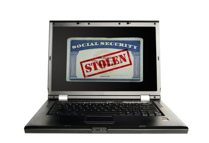 Laptop with a Social Security card and Stolen text in red -- Identity Theft concept