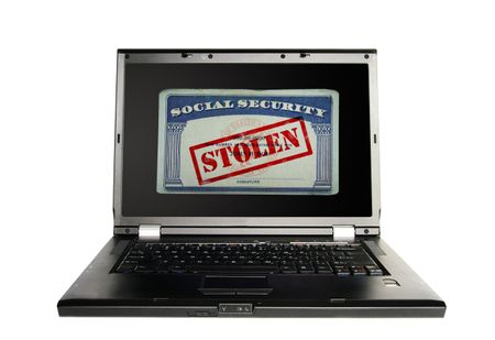Laptop with a Social Security card and Stolen text in red -- Identity Theft concept
