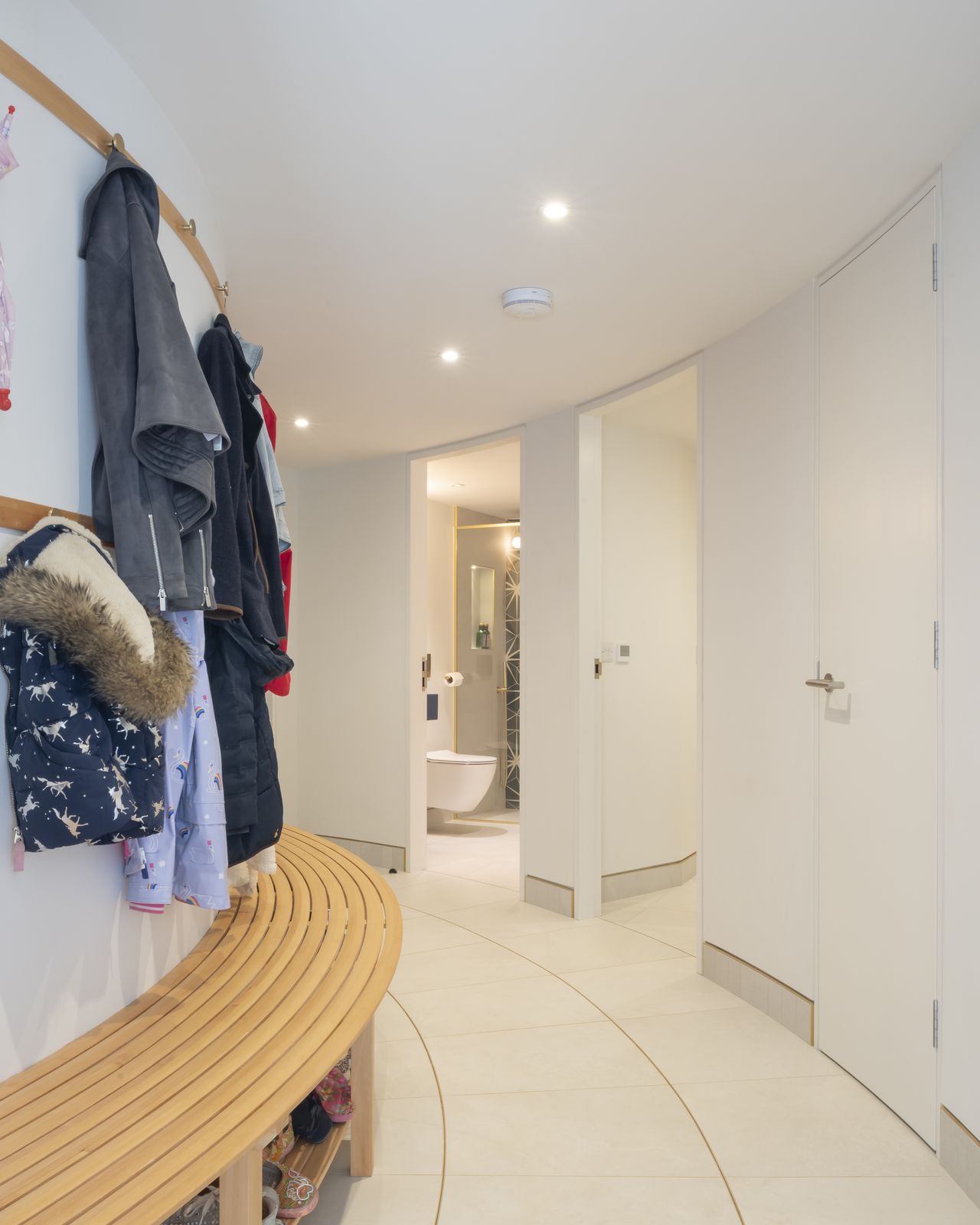 A curved corridor leads to the garage and acts as a boot room with a shower room and utility area.