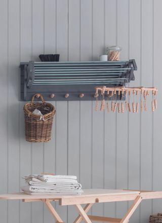 Extendable clothes airer against a blue panelled wall