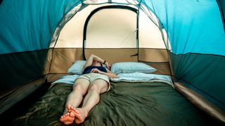 Woman taking a nap inside a camping tent