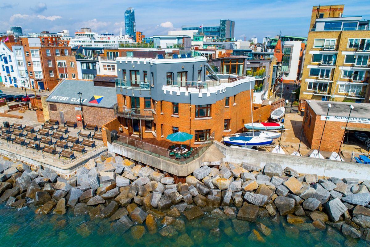 A brick self build surrounded by boats which overlooks the sea