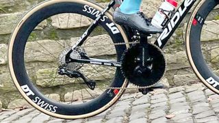 A close up of Victor Campenaerts riding a bike with a Classified hub and massive chainring