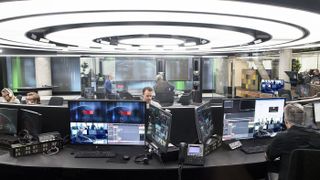 An office with men working in front of displays and monitors controlled by Vizrt solutions. 