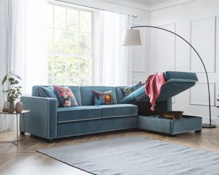 Teal velvet chaise sofa bed with built-in storage.