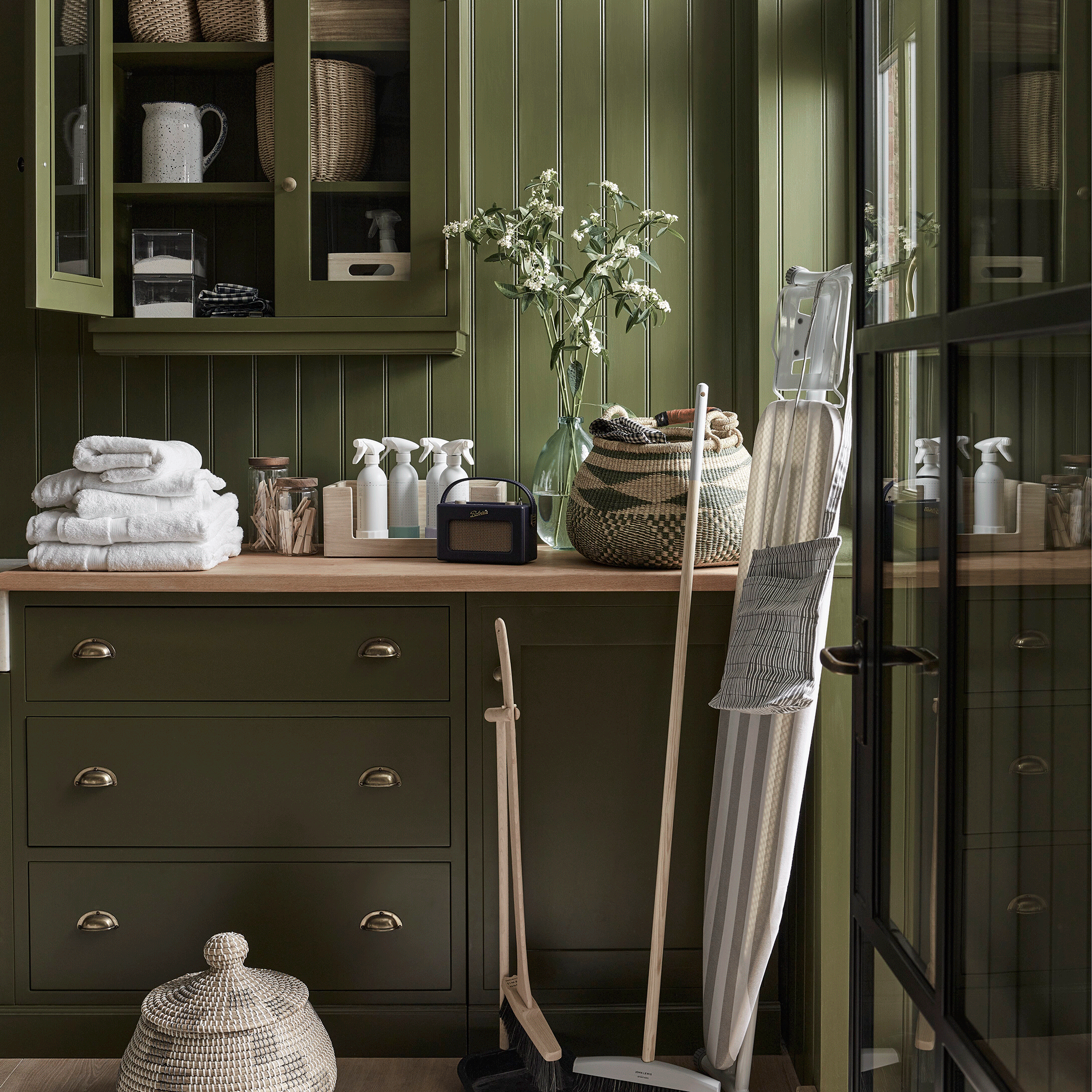 Green utility room with straw storage baskets