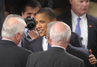 US President Barack Obama (C) greets lawmakers under the watchful eye of White House photographer Pete Souza and security personnel after giving his State of the Union address before a joint session of Congress on January 25, 2011 on Capitol Hill in Washington, DC. AFP PHOTO Nicholas KAMM (Photo credit should read NICHOLAS KAMM/AFP via Getty Images)