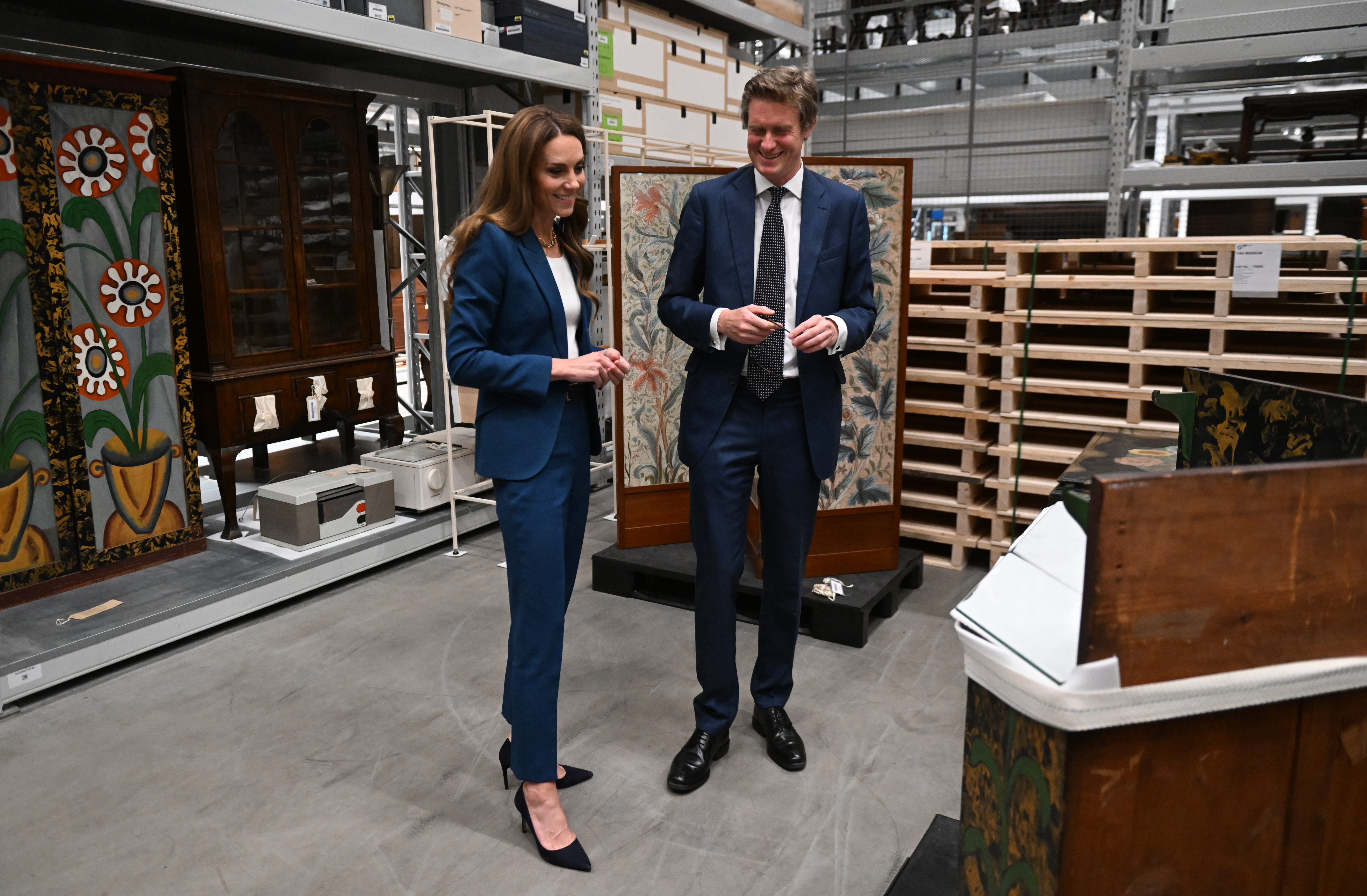 Kate Middleton viewing museum items in a blue suit with Tristram Hunt