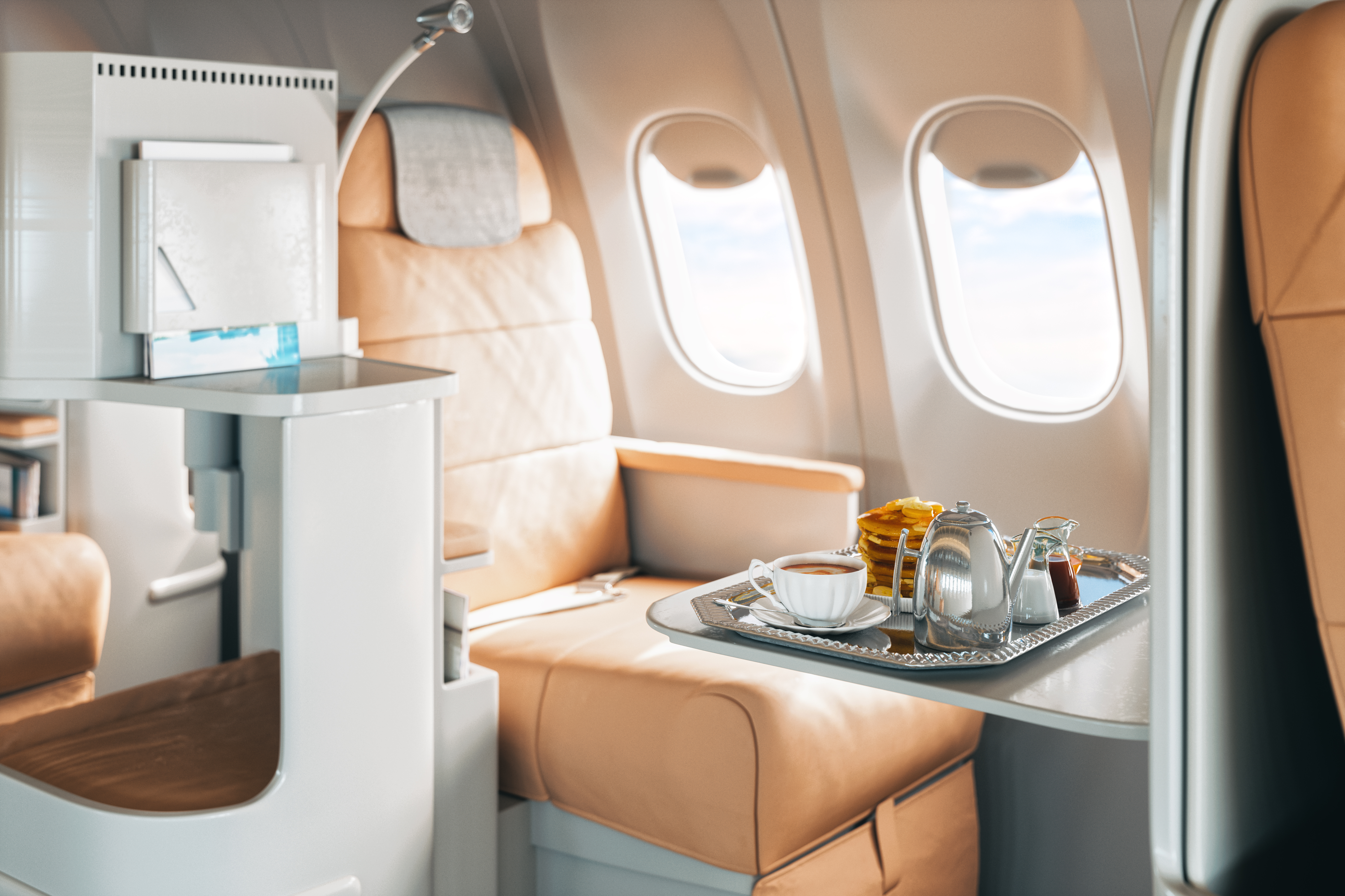 Photograph of first class seat on a plane including breakfast and coffee on a tray.