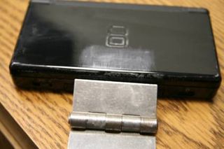 The metal latch is glued on top of the DS cover, with the other end attaching to the folding solar panels.