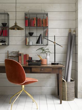 home office with pannelled walls and floors and desk with burnt orange desk chair by pooky
