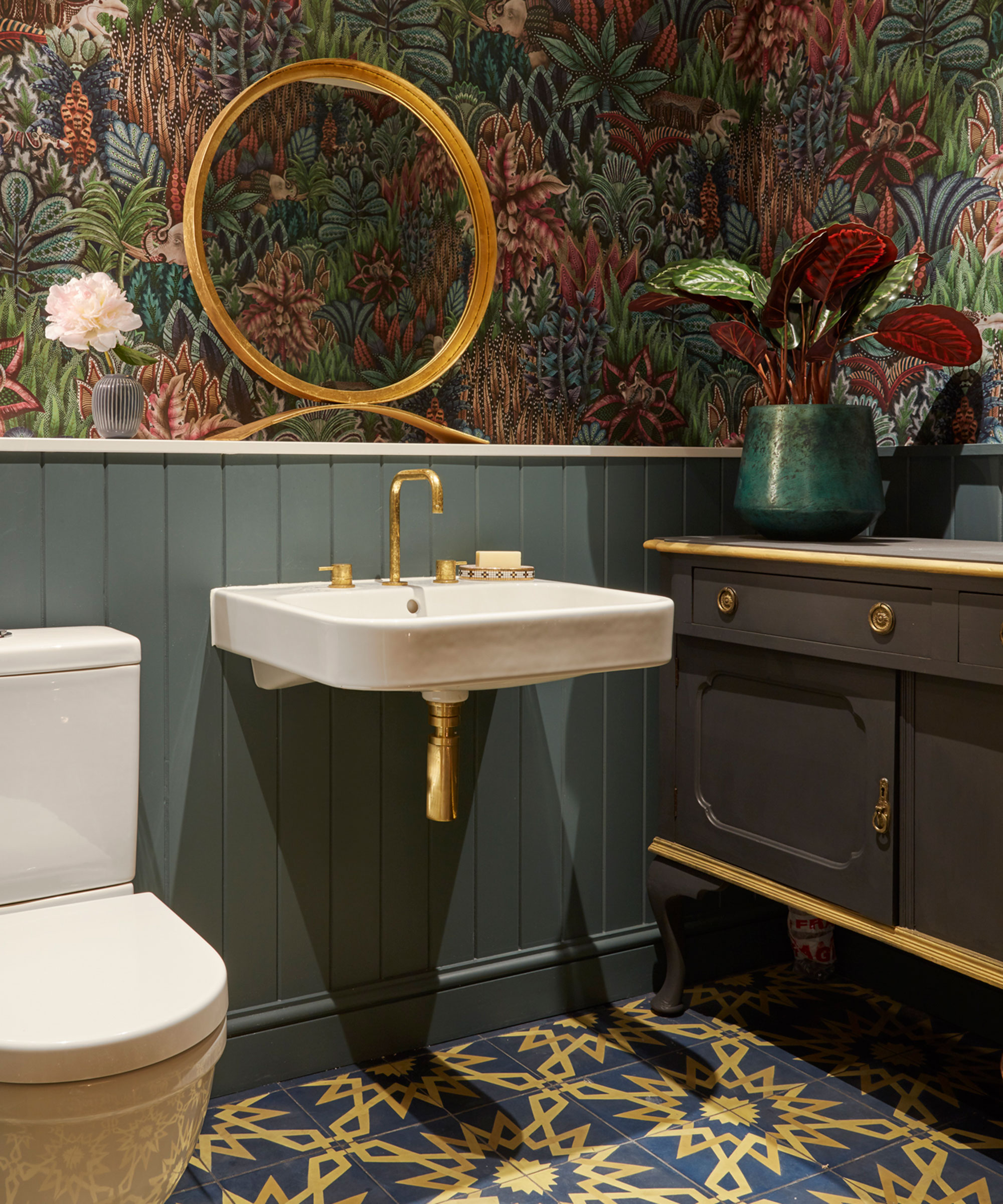 small bathroom with bold wallpaper and painted bathroom wall panelling and blue and yellow floor tiles