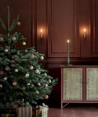 Christmas wall decor ideas with dark red walls, sconces and a Christmas tree