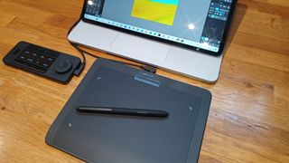 Xencelabs Pen Tablet Small review; a small drawing tablet connected to a laptop on a wooden table