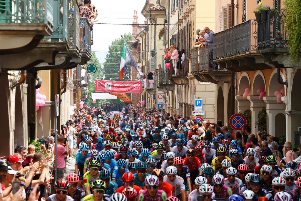Spectators cheer as riders parade through the streets of Rivarolo Canavese at the start of the 15th stage of the Giro dItalia 2022 cycling race 177 kilometers from Rivarolo Canavese Piedmont to Cogne Aosta Valley on May 22 2022 Photo by Luca Bettini AFP Photo by LUCA BETTINIAFP via Getty Images