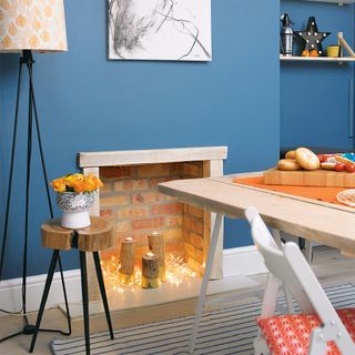 room with blue wall and fireplace and light cord and table with chairs