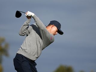 Collin Morikawa hitting a tee shot at the President's Cup, demonstrating a bowed left wrist at the top of the backswing which helps him to hit his trademark soft fade shot