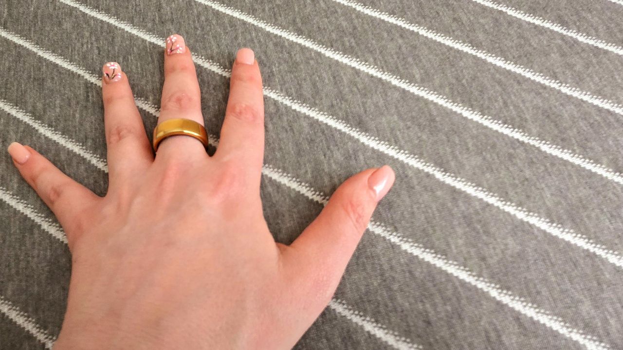 Tester's manicured hand on the cover of the Siena Premier Hybrid Mattress