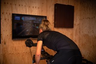 Female cyclist riding indoors on a turbo trainer at a high cadence