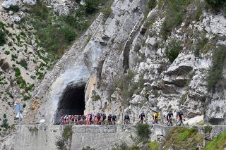 The peloton cuts through the mountains