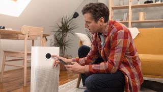 man turning on an air purifier in his home