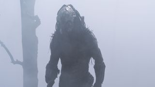 The Predator emerges from a smoke-filled area and walks to the left of the camera in 20th Century Studios' Prey film
