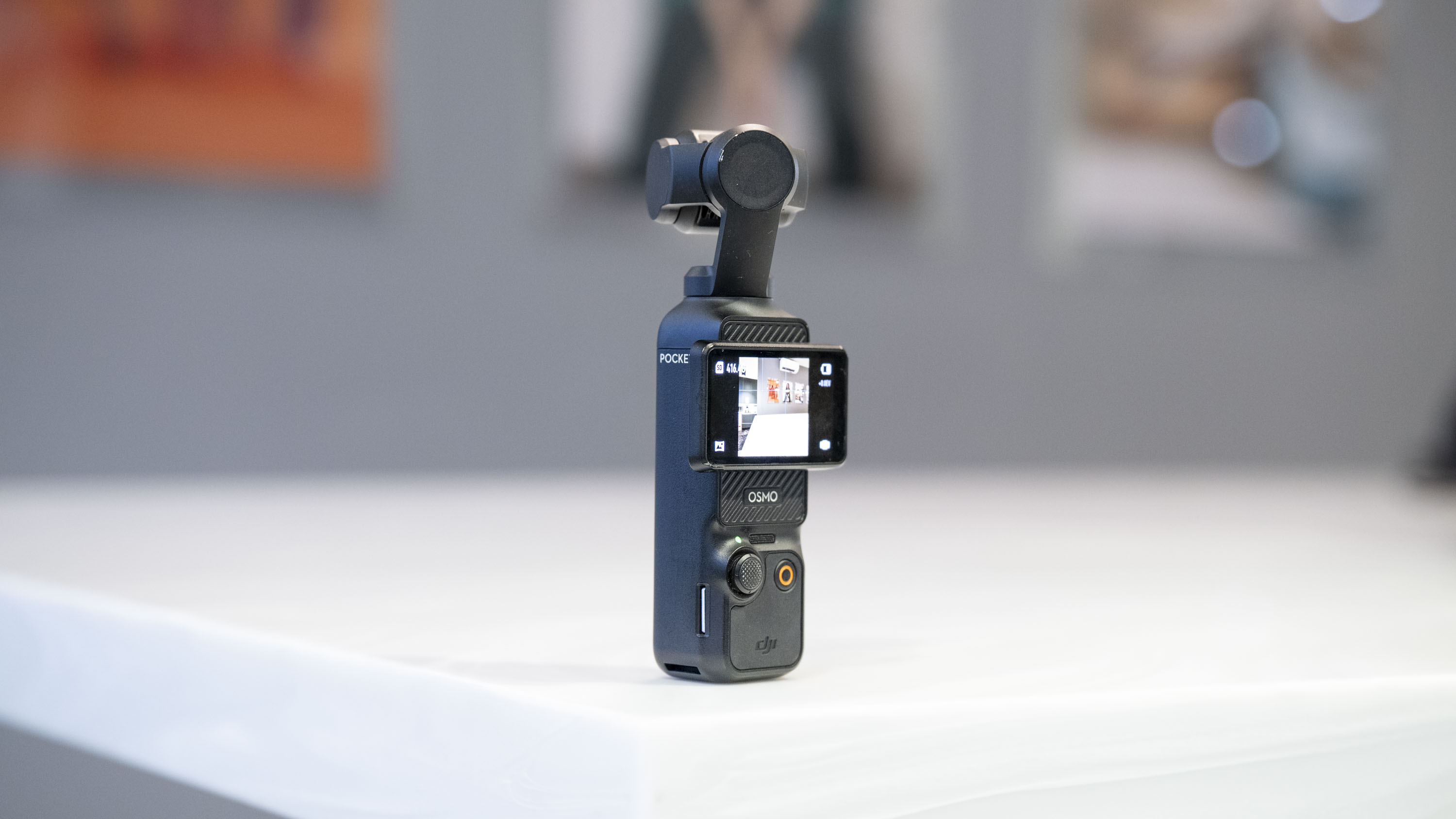 DJI Osmo Pocket 3 vlogging camera stood on a white marble-effect table