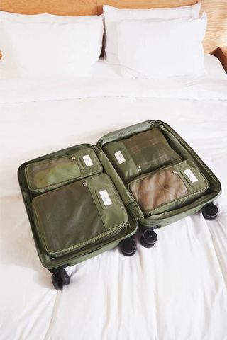 Olive green Béis packing cubes inside a Béis suitcase