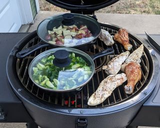 meat and vegetables cooking on a kamado grill