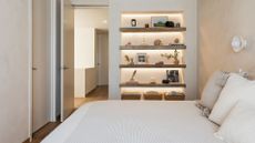 A bedroom with a twin sized bed and a bookshelf 