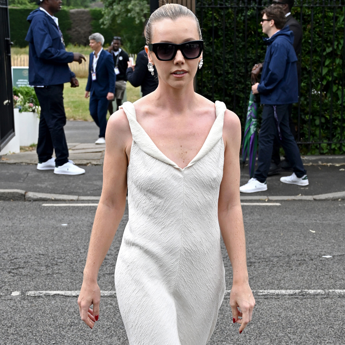 A guest at Wimbledon wears a pair of white pointed-toe shoes and a cream dress to the tournament 