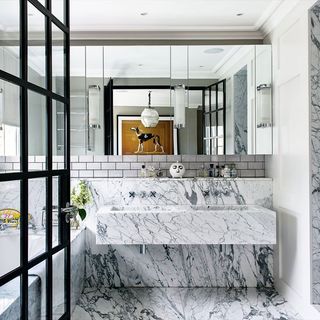 bathroom with marble flooring and mirror on wall