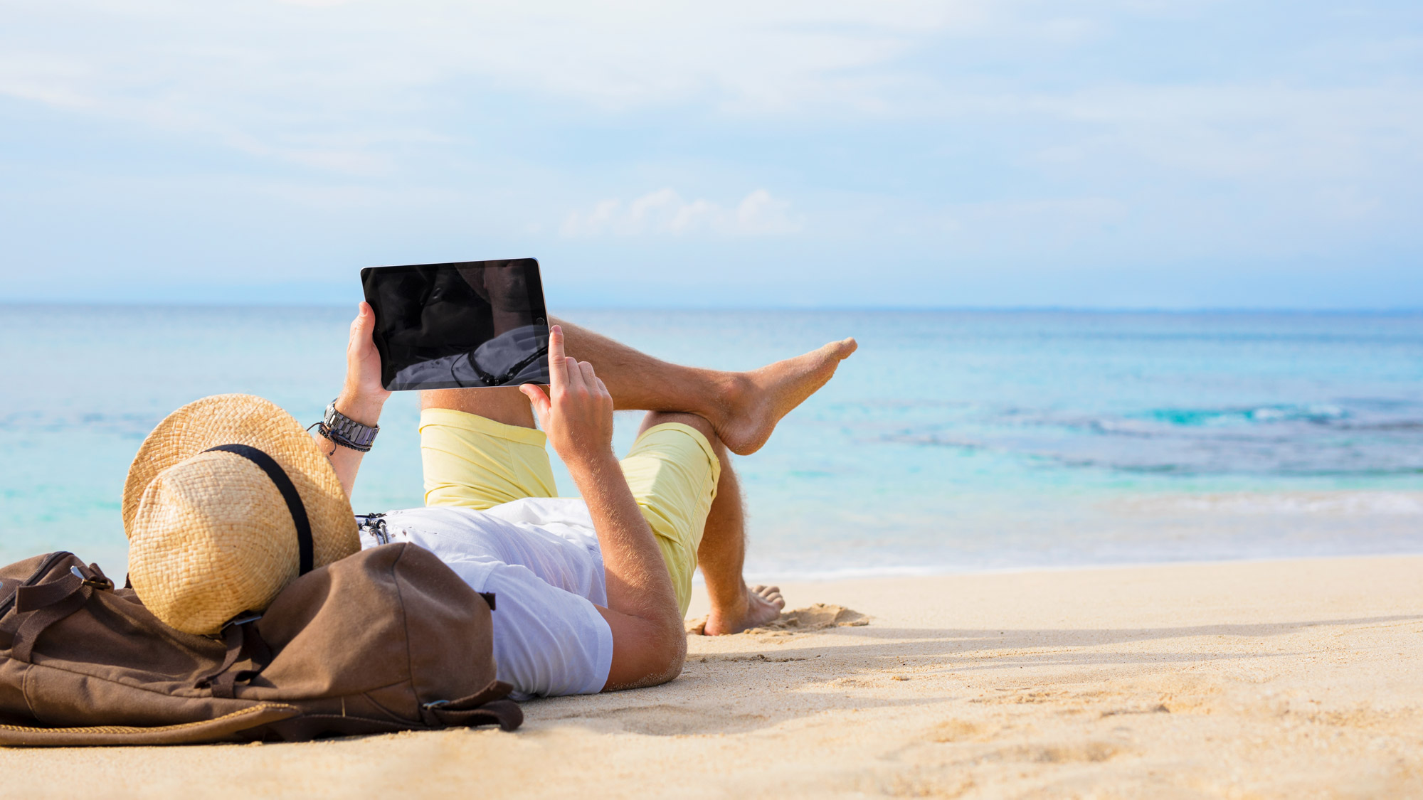 Man with tablet on the beach