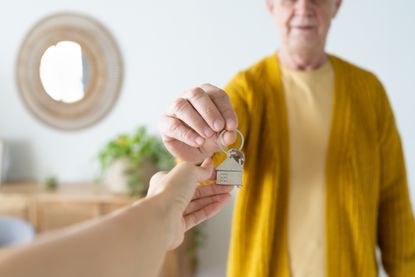 Man giving the house keys to another person