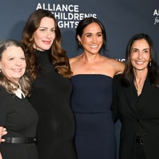 Meghan Markle posing with friends in a navy gown at the Alliance for Chilren's Rights event