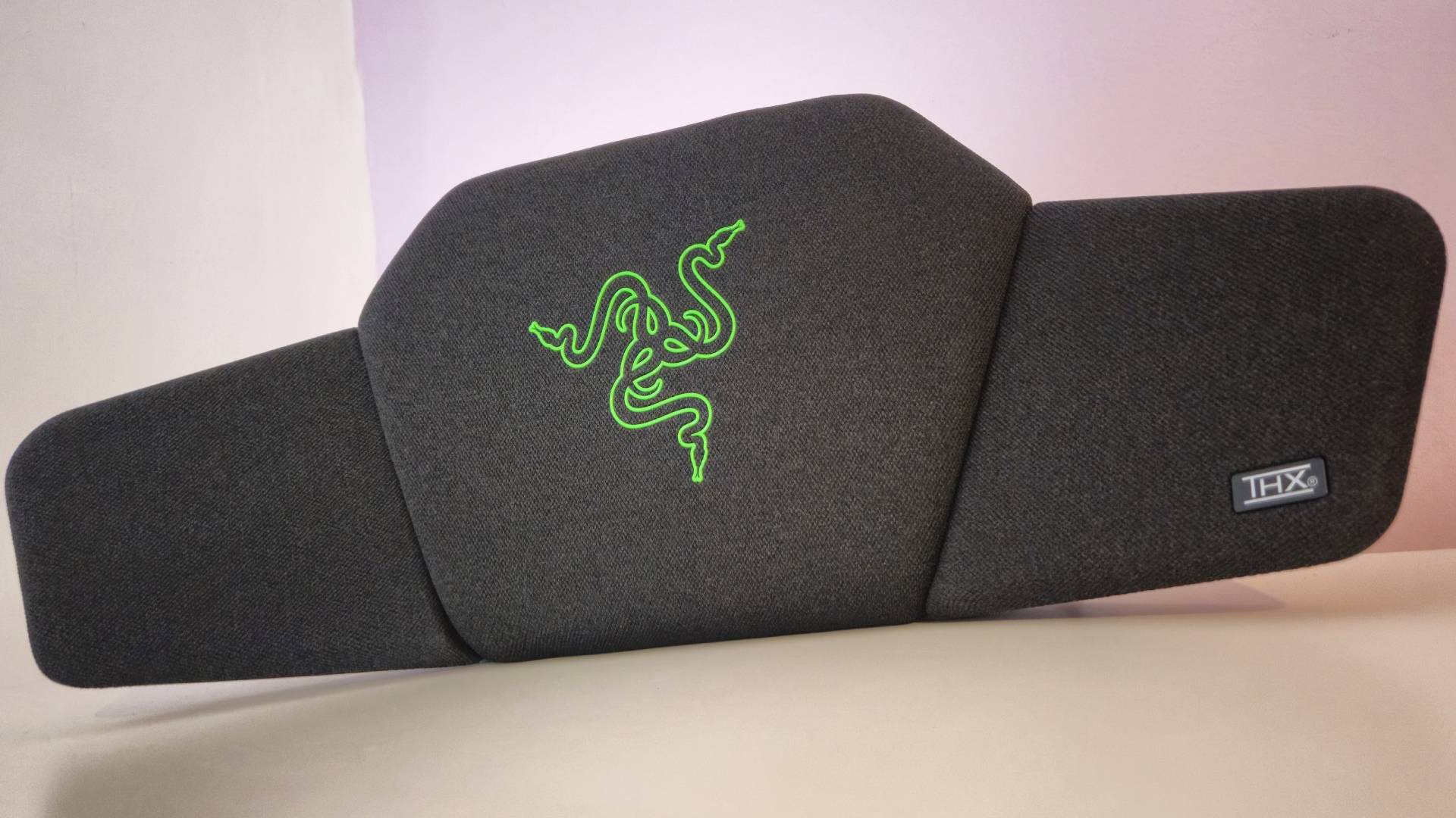 Photo by Rosalie Newcombe of the Razer Clio wireless speaker head cushion sitting on a white desk.