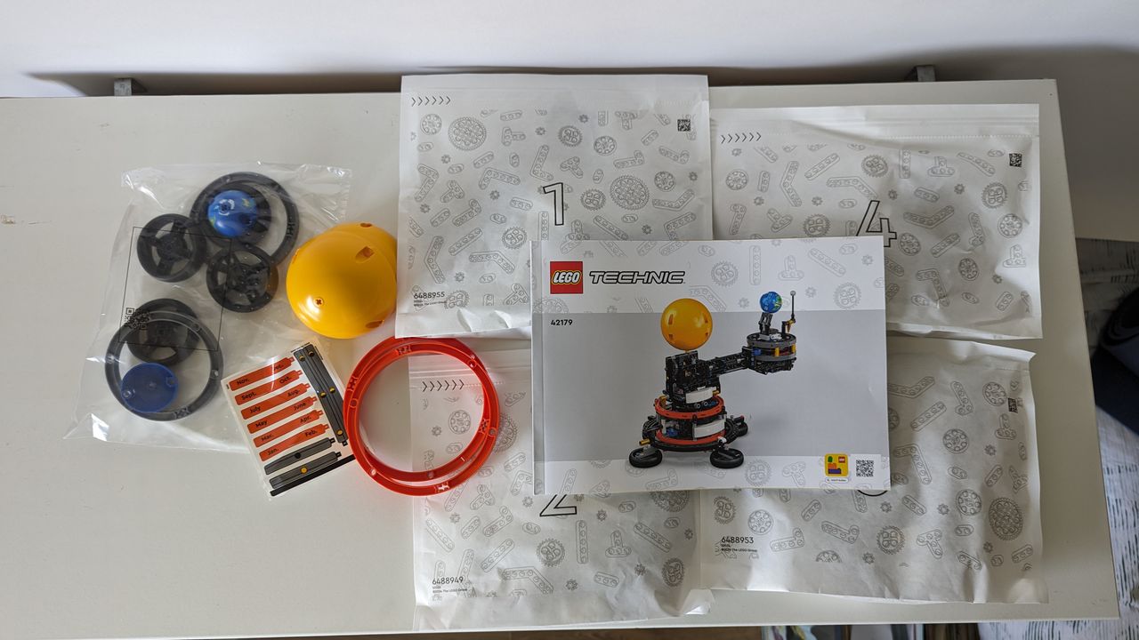 Lego technic planet earth and moon in orbit set on a white background