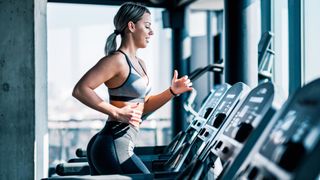Woman running on a treadmill during treadmill workout, left arm forward right arm back