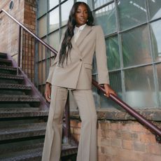 Model wears Marks and Spencer black slip dress with red bag and white kitten heel shoes.