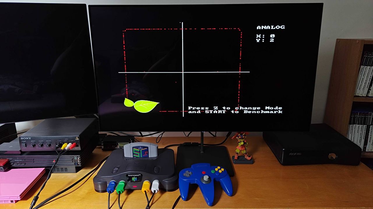 Modded N64 controller connected to original console with benchmark software on screen showing thumbstick reading.