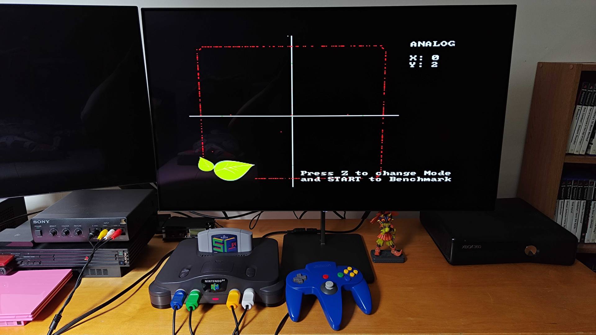 Modded N64 controller connected to original console with benchmark software on screen showing thumbstick reading.