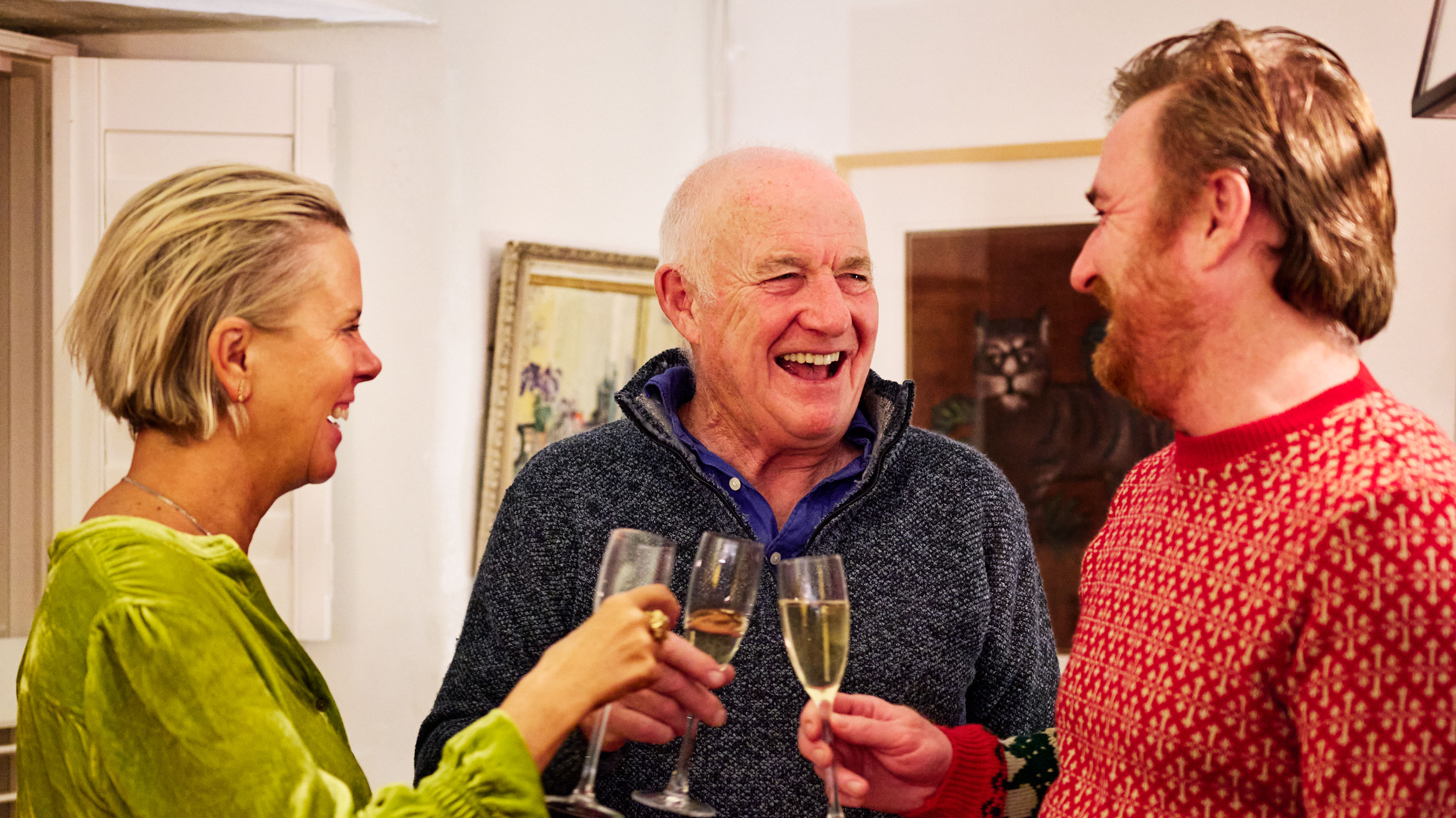 Rick Stein with his wife toasting with a glass of champagne in a living room