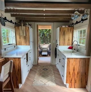 Kitchen of tiny home with ceiling racks for storage