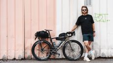 Jack Thompson, ultracyclist, standing next to his custom 2 speed Specialized Roubaix SL8 ahead of his project 1903 challenge. 