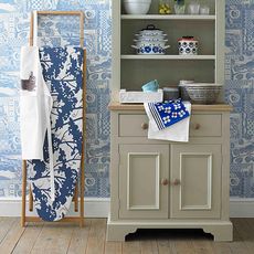 ironing board covers white shelf and blue printed wall