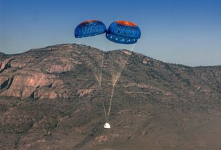 Blue Origin's New Shepard spacecraft returns to Earth under parachutes during a suborbital launch test flight from West Texas on April 29, 2015.