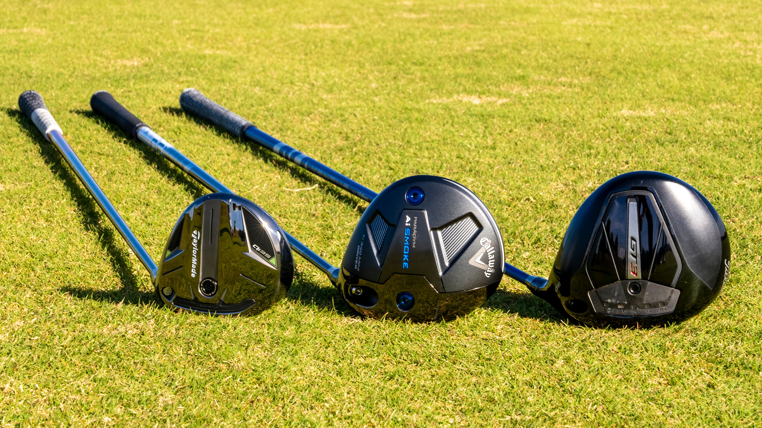 Metalwoods in a row on the grass