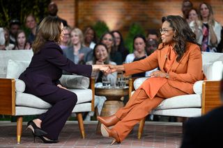 Kamala Harris and Oprah Winfrey onstage at the Unite America Rally in fall suiting