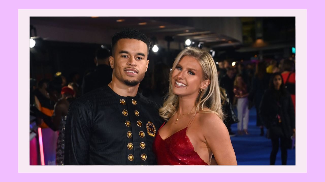 Toby Aromolaran and Chloe Burrows smiling and posing together on the red carpet for the TV Palooza! at The Royal Festival Hall on November 23, 2021 in London, England. In a purple template 